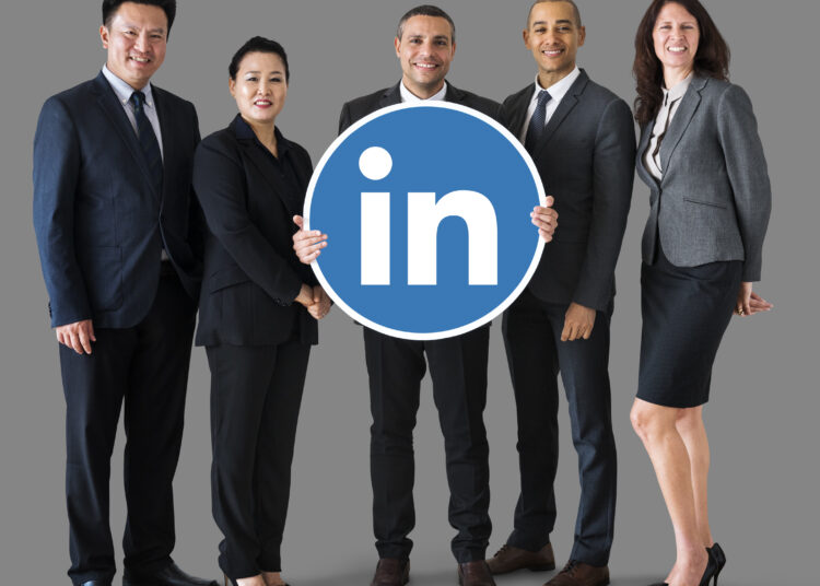 business people holding linkedin logo scaled
